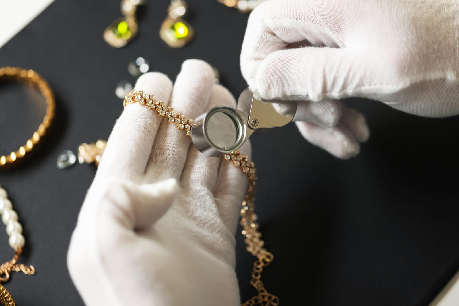 Vitrine iluminada de ourivesaria com peças em prata e ouro dispostas sobre veludo